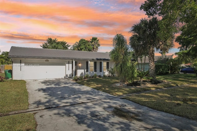 single story home featuring a lawn and a garage