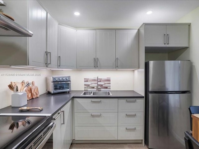 kitchen with stainless steel appliances, extractor fan, and sink