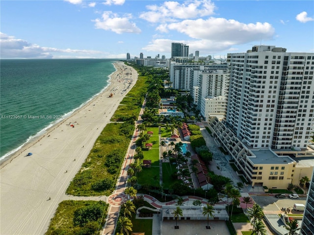 birds eye view of property with a water view and a beach view