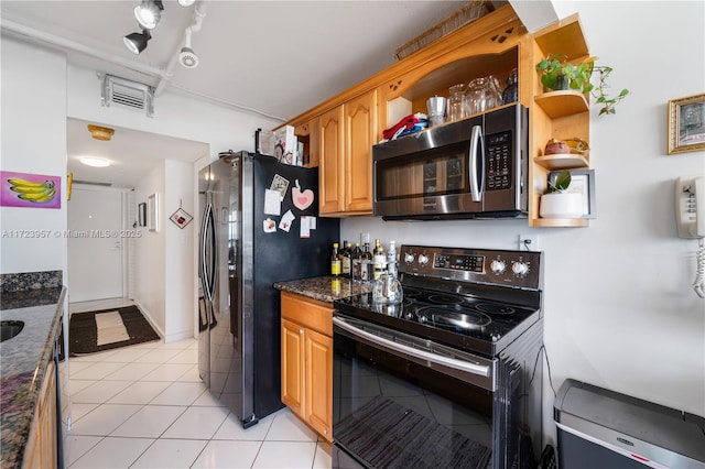 kitchen featuring light tile patterned floors, dark stone counters, and appliances with stainless steel finishes