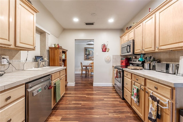 kitchen featuring tile counters, sink, stainless steel appliances, tasteful backsplash, and light brown cabinetry