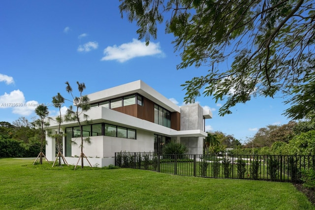 view of side of home featuring a fenced front yard and a lawn