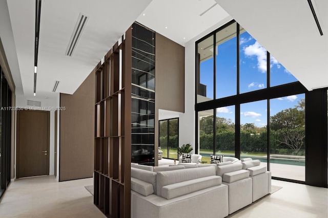 unfurnished living room featuring floor to ceiling windows, visible vents, and a high ceiling