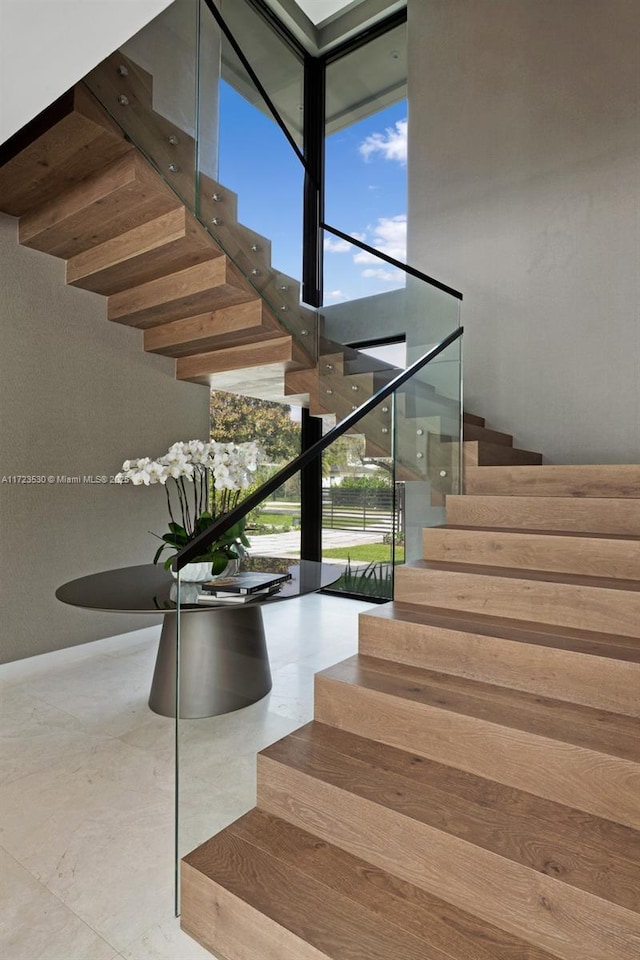 stairs with expansive windows and a towering ceiling