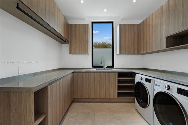 laundry room featuring recessed lighting, cabinet space, independent washer and dryer, and a sink