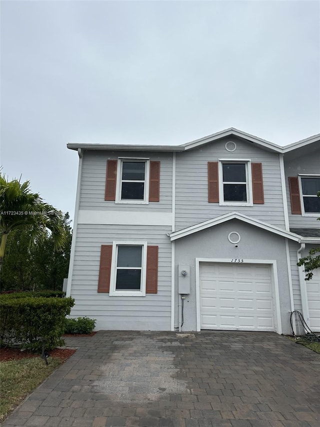 view of front of property featuring a garage and decorative driveway