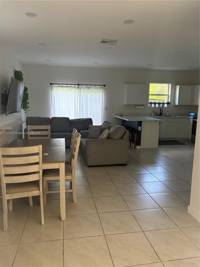 dining area with light tile patterned floors and visible vents