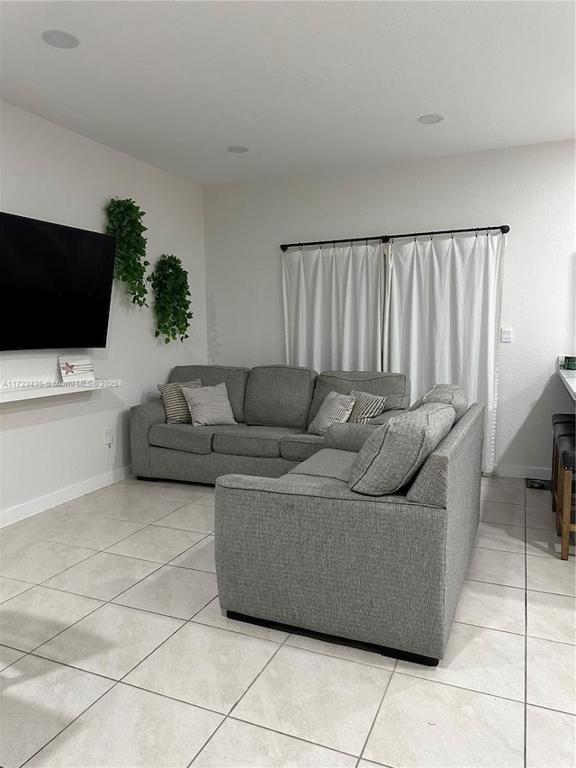 living area with light tile patterned flooring and baseboards