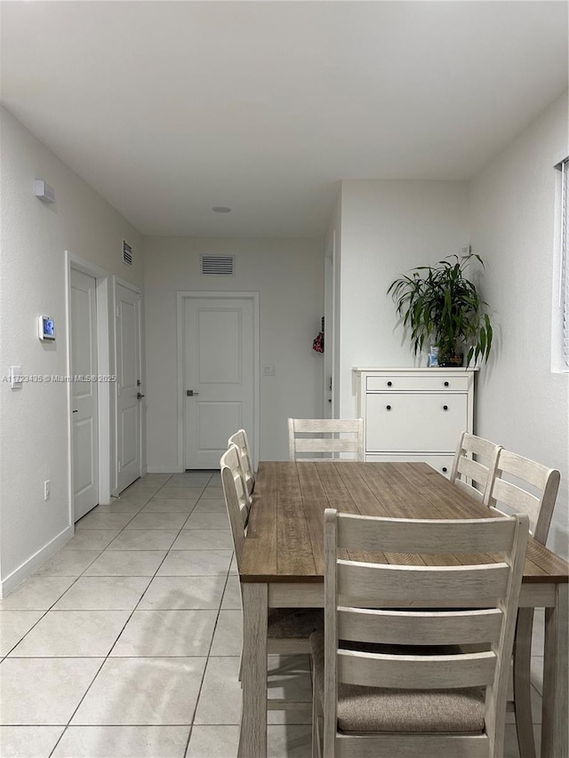 dining room featuring light tile patterned floors, visible vents, and baseboards