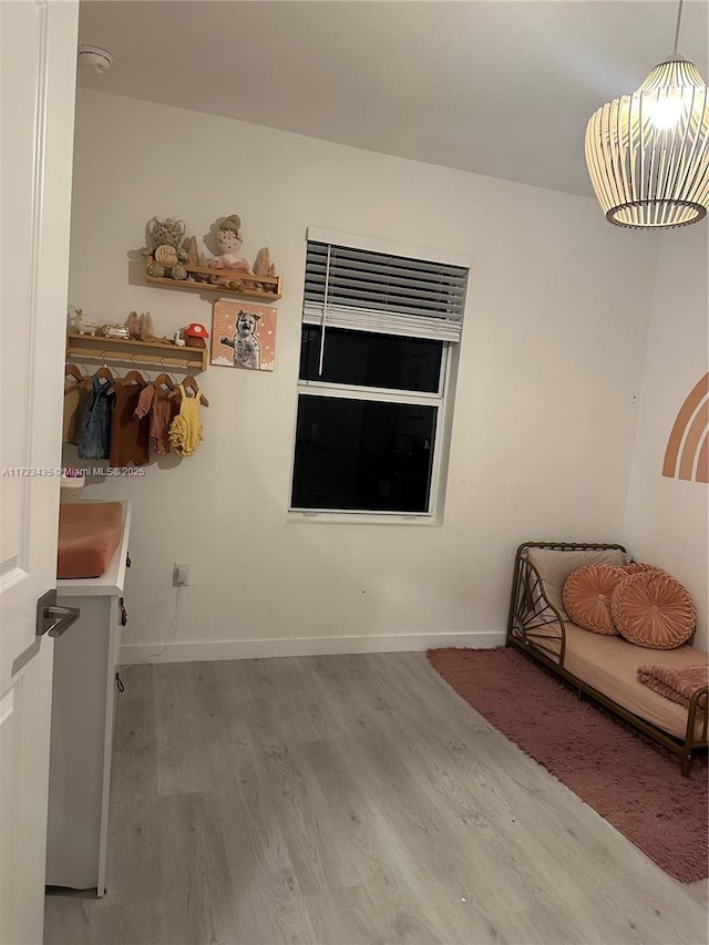 living area with baseboards and wood finished floors