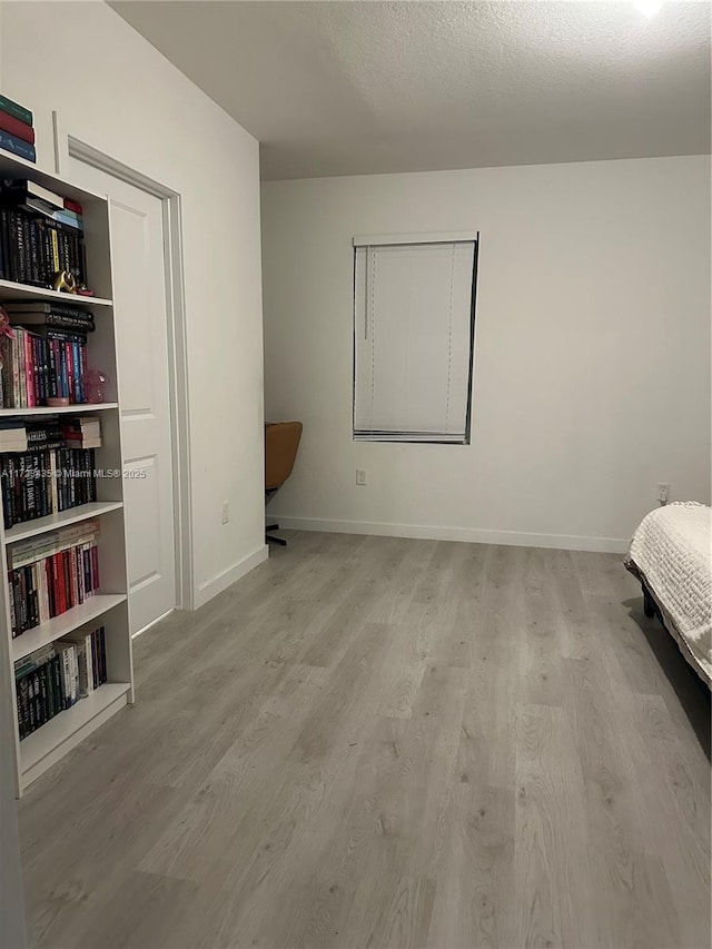 bedroom featuring wood finished floors and baseboards