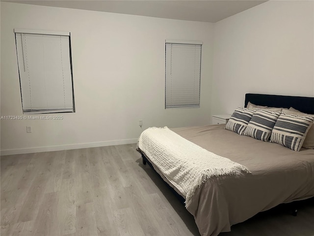 bedroom with light wood-type flooring and baseboards