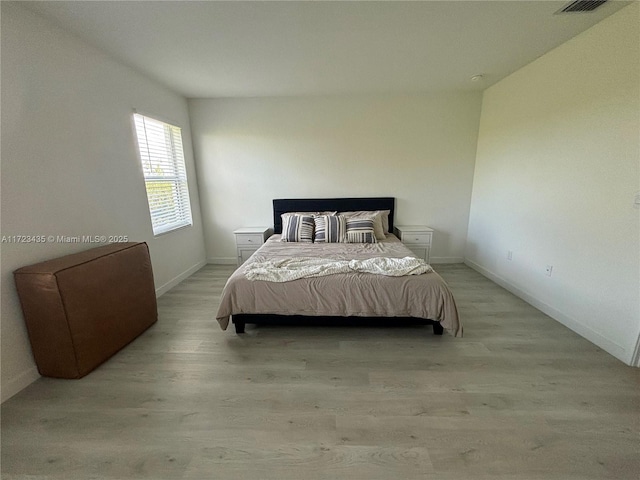 bedroom featuring light wood-style flooring and baseboards