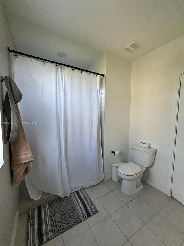 bathroom with toilet, curtained shower, tile patterned flooring, and visible vents