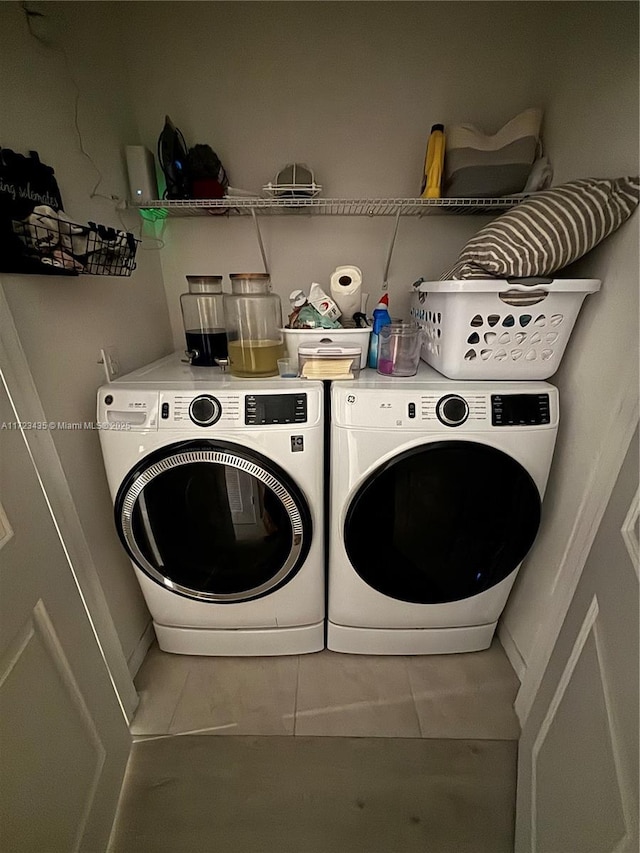 clothes washing area featuring tile patterned floors, laundry area, and separate washer and dryer