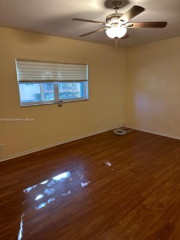 unfurnished room featuring dark hardwood / wood-style flooring and ceiling fan