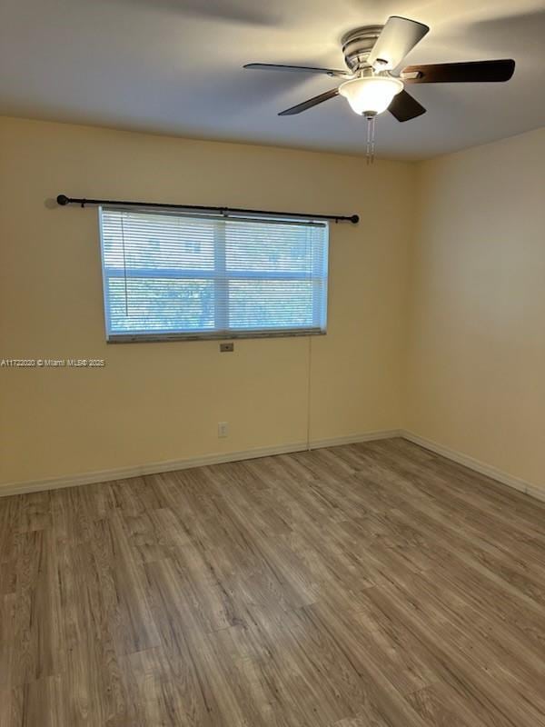 unfurnished room with hardwood / wood-style floors and ceiling fan