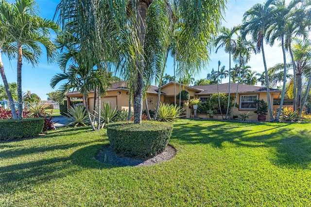 ranch-style home featuring a garage and a front lawn