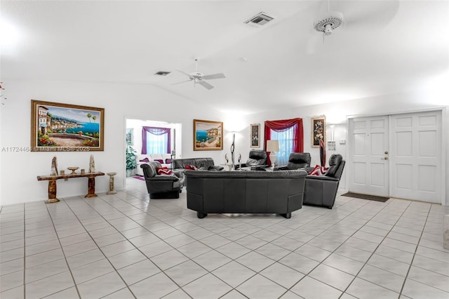 living room featuring ceiling fan, lofted ceiling, and light tile patterned floors