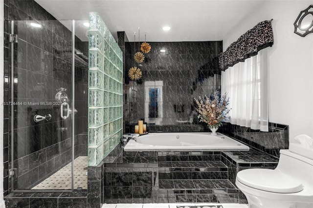 bathroom with toilet, tile walls, and plus walk in shower