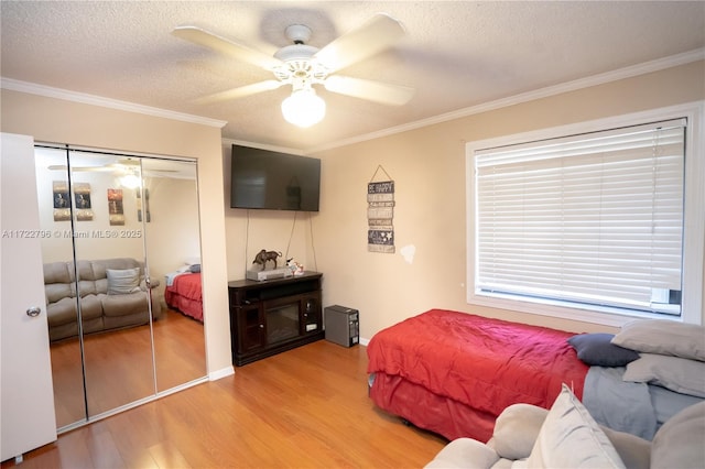 bedroom with ceiling fan, a closet, and crown molding