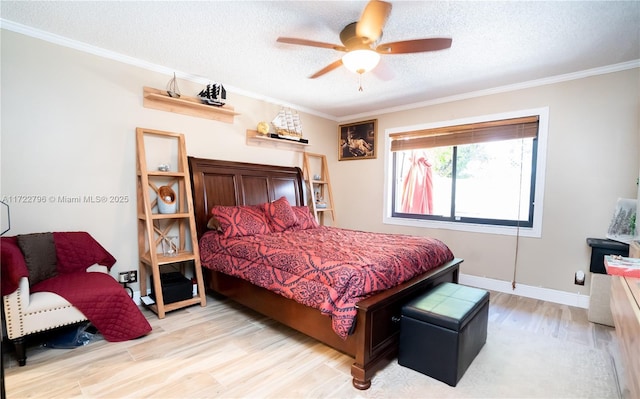 bedroom featuring light wood-type flooring, a textured ceiling, ceiling fan, and crown molding