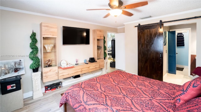 bedroom featuring ceiling fan, a barn door, ornamental molding, and a textured ceiling