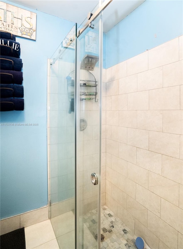 bathroom featuring tile patterned flooring and a shower with shower door