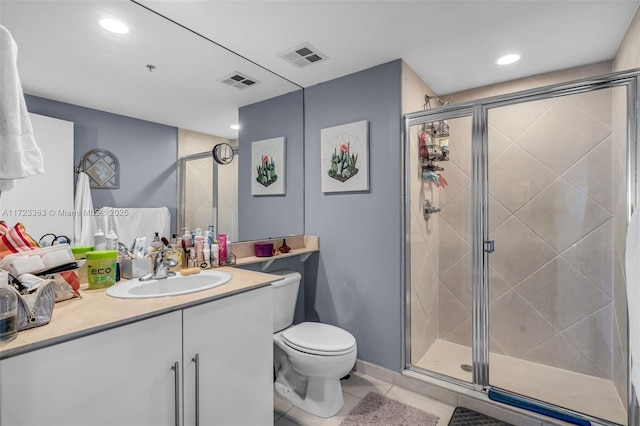 bathroom with tile patterned flooring, vanity, toilet, and a shower with shower door