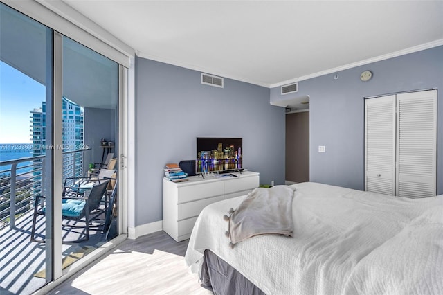 bedroom featuring access to exterior, crown molding, a closet, and light hardwood / wood-style flooring