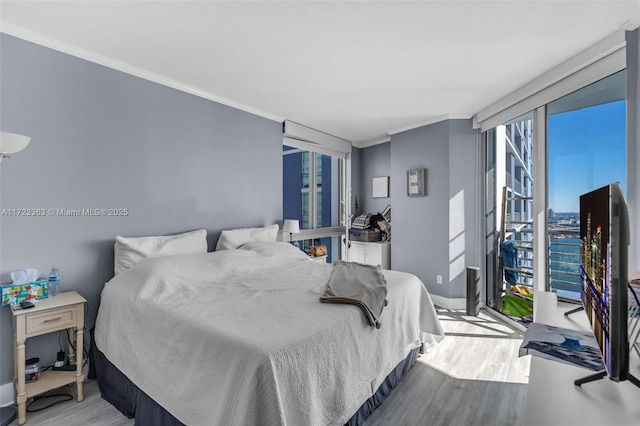 bedroom with ornamental molding and light hardwood / wood-style flooring