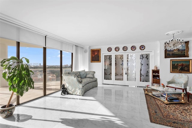 living area featuring crown molding, marble finish floor, and a chandelier