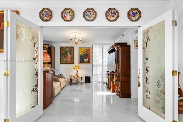 corridor with a notable chandelier, marble finish floor, and ornamental molding