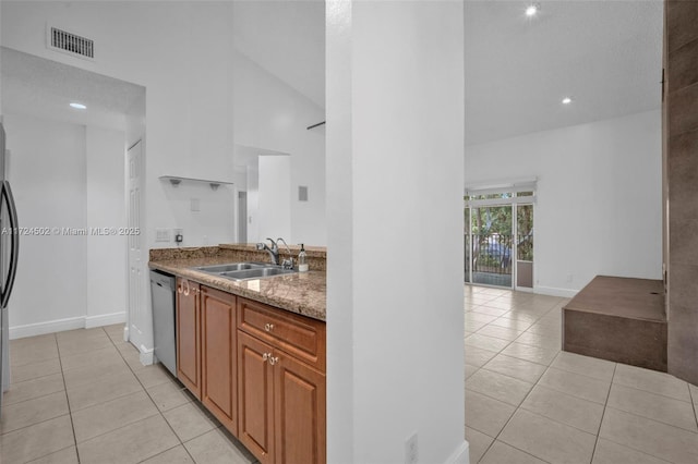 kitchen featuring dishwasher, light tile patterned floors, light stone countertops, and sink