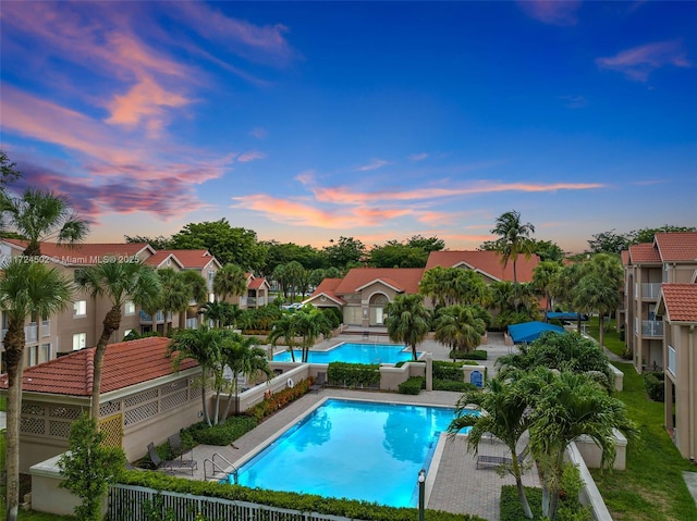 pool at dusk featuring a patio area