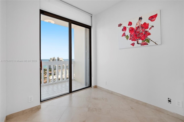 tiled empty room featuring a wall of windows