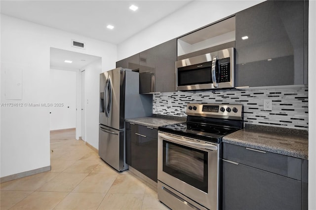 kitchen featuring decorative backsplash, light tile patterned floors, and appliances with stainless steel finishes