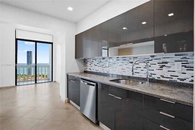 kitchen with dishwasher, sink, backsplash, dark stone countertops, and a water view