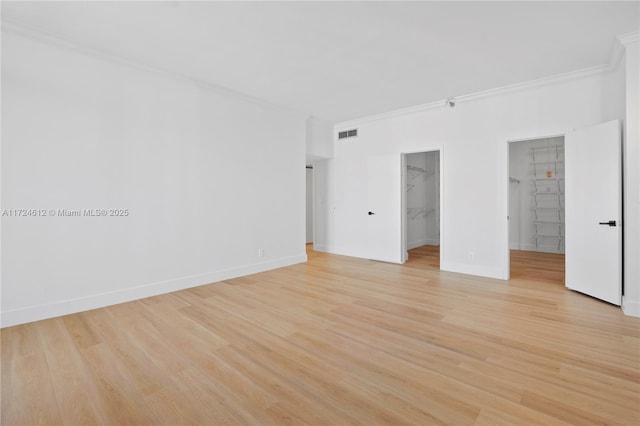 unfurnished room featuring ornamental molding and light hardwood / wood-style floors