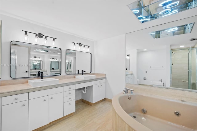 bathroom with plus walk in shower, wood-type flooring, and vanity