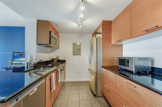 kitchen with appliances with stainless steel finishes, track lighting, sink, light tile patterned floors, and electric panel