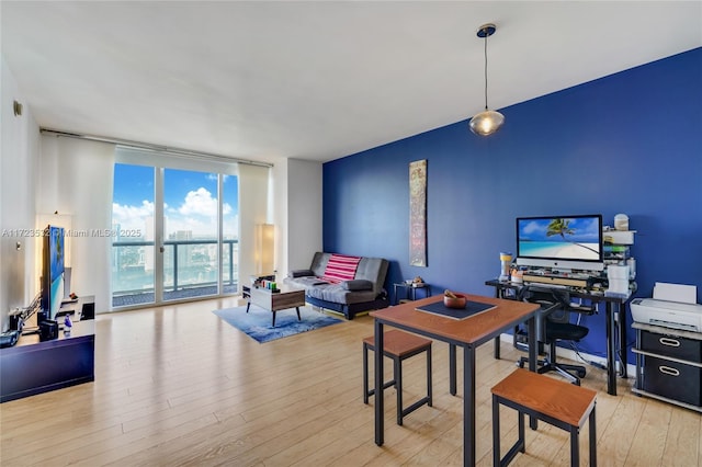 home office with light wood-type flooring and expansive windows