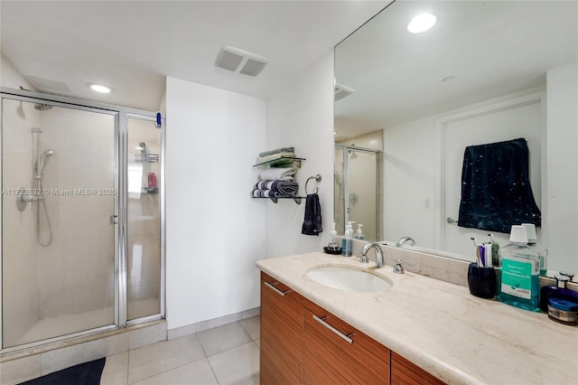 bathroom with tile patterned flooring, vanity, and walk in shower