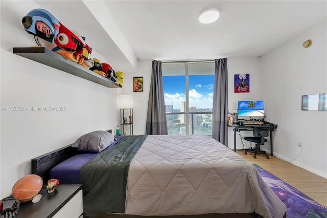 bedroom featuring floor to ceiling windows and wood-type flooring