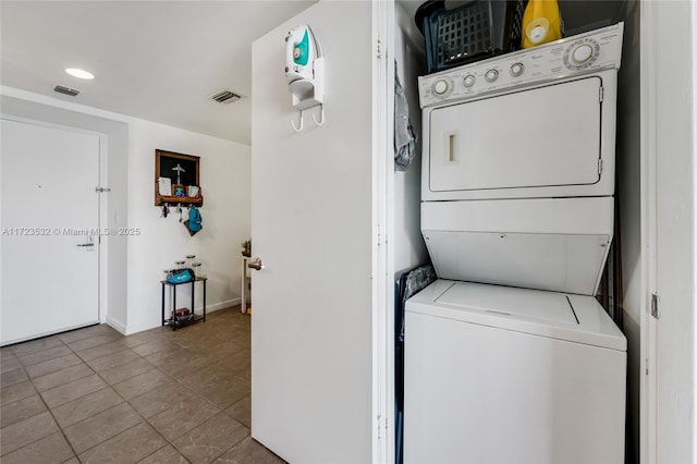 laundry area with tile patterned flooring and stacked washer and dryer