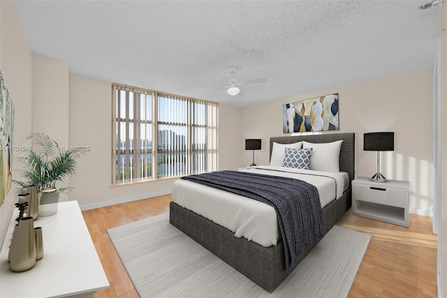 3530 Mystic Pointe Dr Unit 710, Aventura, FL 33180 - bedroom featuring ceiling fan, baseboards, a textured ceiling, and light wood-type flooring