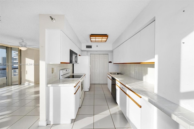 3530 Mystic Pointe Dr Unit 710, Aventura, FL 33180 - kitchen featuring backsplash, tile countertops, and black appliances