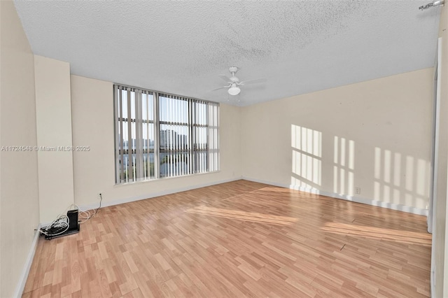 3530 Mystic Pointe Dr Unit 710, Aventura, FL 33180 - empty room with ceiling fan, baseboards, wood finished floors, and a textured ceiling