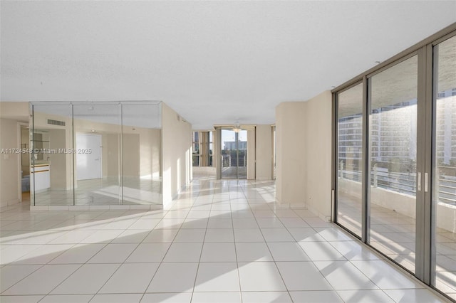 3530 Mystic Pointe Dr Unit 710, Aventura, FL 33180 - tiled empty room featuring visible vents and a wall of windows