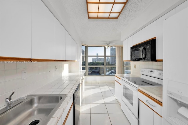 3530 Mystic Pointe Dr Unit 710, Aventura, FL 33180 - kitchen featuring tile counters, a sink, white appliances, and a textured ceiling